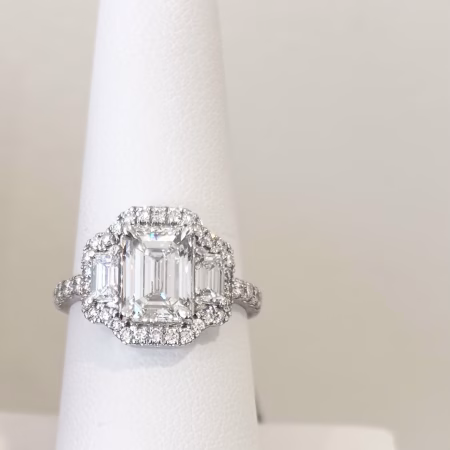 14K white gold emerald cut diamond ring with halo, side emerald cut diamonds, and diamond band.